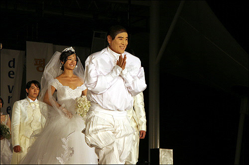 세계적 패션디자이너 앙드레 김이 '2006 세계평화축전'에서 평화를 디자인한 패션쇼를 마치고 주역 모델인 박다안 등과 함께 관객들에게 인사하고 있다.