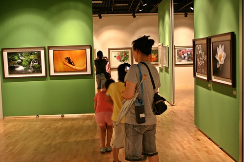  방학을 맞은 아이들이 엄마 손을 잡고 전시 작품을 구경하면서 사진을 찍고 있다. 