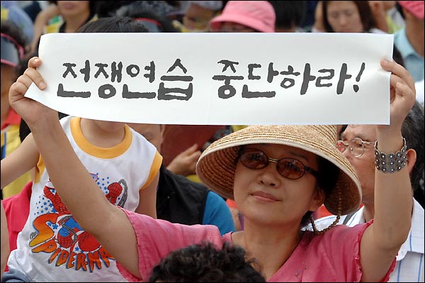 8월 15일 오후 서울역광장에서 개최된 '광복 65년 천안함 진실규명 한반도 평화실현 8.15대회' 참석자가 "전쟁연습 중단하라"라고 씌어진 현수막을 펼쳐보이고 있다.