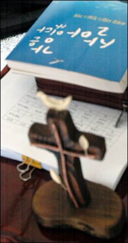 금식기도회장에 놓여 있는 십자가와 '강은 살아있다' 제목의 책  