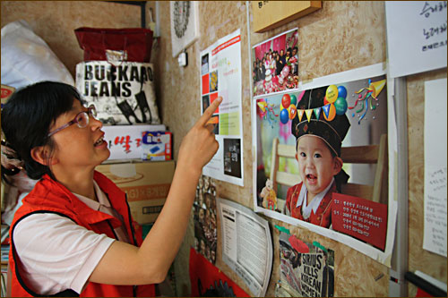 김소연(41) 금속노조 기륭전자분회장이 17일 오후 서울 금천구 가산동 옛 사옥 앞에 있는 컨테이너 박스에서 조합원 자녀들의 사진을 보며 웃고 있다.