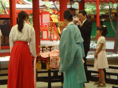 　　일본에서는 병원에서 아기를 낳으면 집으로 가지 않고 신사에 가서 신사 신관인 구지(宮司)의 축원을 받고 집에 갑니다. 신사 본전 안에서 구지(宮司)의 축원을 받고 있는 모습입니다. 이들 구지(宮司)는 대부분 일본 국학원대학(國學院大學)을 졸업한 사람이 많습니다. 빨간 치마를 입은 사람은 미코(巫女)라고 하여 구지를 돕는 사람입니다. 이 미코(巫女)의 왼쪽에 아기 엄마가 있습니다.