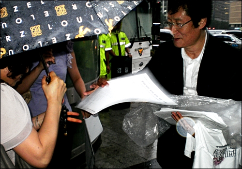 배우 문성근씨가 27일 '야권단일정당운동'을 제안하는 제안문을 시민들에게 나눠주고 있다.