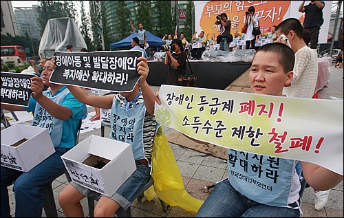 장애자녀를 둔 부모들이 8월 31일 오후 서울 종로구 보신각 앞에서 열린 '장애인부모 전국집중결의대회'에서 장애인 복지 예산 확보와 장애아동 및 발달장애인의 권리보장을 촉구하며 삭발한 뒤 구호를 외치고 있다.