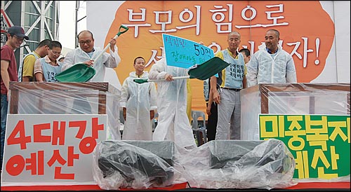 장애자녀를 둔 부모들이 31일 오후 서울 종로구 보신각 앞에서 열린 '장애인부모 전국집중결의대회'에서 4대강 사업의 예산을 장애인 복지 예산으로 옮기는 퍼포먼스를 하고 있다.
