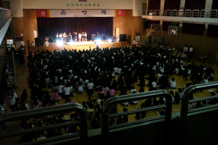 강당을 가득 매운 학생들이 축제를 즐기고 있다.