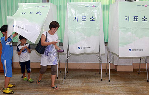 7.28 재·보궐선거일인 28일 오후 서울 불광동 불광초등학교에 마련된 제3투표소에서 아이들이 어머니와 함께 기표를 마친 뒤 기표소를 나오고 있다.