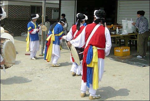  개업집 앞마당. 회원들은 풍물굿에 열중이고, 주인아주머니는 두 손을 모으고 비느라 정신없습니다. 요즘엔 보기 드문 풍경이지요. 
