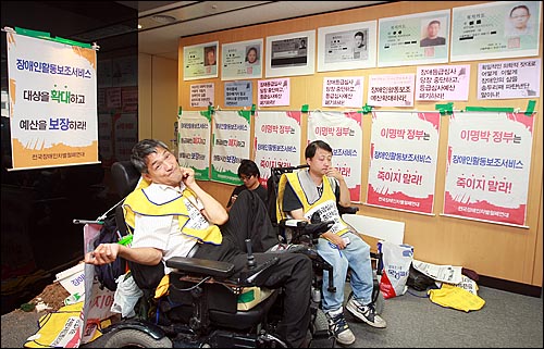 전국장애인차별철폐연대 회원들과 중증장애인들이 13일 오후 서울 광진구 국민연금관리공단 장애심사센터를 기습점거해 장애인등급제에 대한 항의의 뜻으로 반납한 장애인 복지카드 복사본을 벽에 붙여놓고 있다.