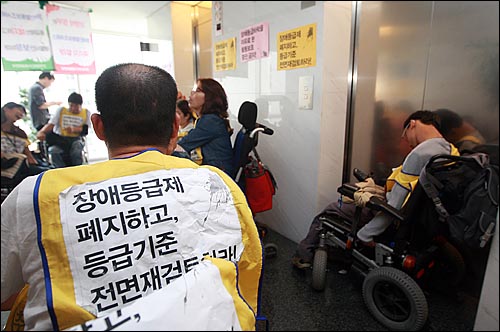 전국장애인차별철폐연대 회원들과 중증장애인들이 13일 오후 서울 광진구 국민연금관리공단 장애심사센터를 기습점거해 장애등급제심사 철회와 등급기준 전면재검토를 요구하며 농성을 벌이고 있다.