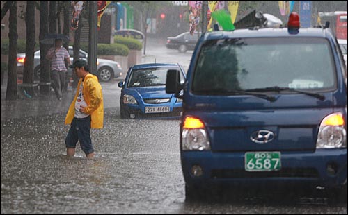 민족 최대 명절인 추석 연휴 첫날인 21일 오후 서울·경기 지역에 시간당 최대 100mm의 폭우가 쏟아진 가운데, 종로구 청계천 인근 도로에 물이 불어나 차량들이 물에 잠겨 있다.    