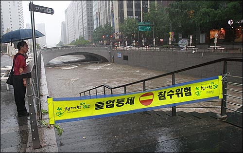 민족 최대 명절인 추석 연휴 첫날인 9월 21일 오후 서울·경기 지역에 시간당 최대 100mm의 폭우가 쏟아진 가운데, 종로구 청계천 산책로가 물에 잠겨 시민들의 출입이 통제되고 있다.