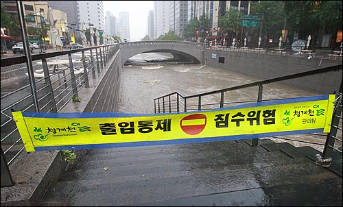 민족 최대 명절인 추석 연휴 첫날인 21일 오후 서울·경기 지역에 시간당 최대 100mm의 폭우가 쏟아진 가운데, 종로구 청계천 산책로가 물에 잠겨 시민들의 출입이 통제되고 있다.