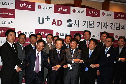 30일 오전 남대문 서울힐튼호텔에서 열린 U+AD 출시 기자 간담회에서 LGU+ 간부들과 제휴사 관계자들이 손을 맞잡고 있다.