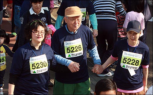  10일 오전 인천시 강화군 길상면 길상공설운동장에서 열린 <오마이뉴스> '2010 강화 바다사랑 마라톤대회'에 참가한 우리마을 김성수 주교(가운데)가 장애인들과 함께 손을 잡고 출발하고 있다.
