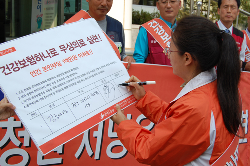 김혜영 민노당 충남도당위원장이 입법청원 서명서에 서명을 하는 포퍼먼스를 하고 있다.