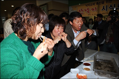 20일, 성동구청 직원들이 낙지 소비 촉진을 위해 낙지 머리까지 통째로 먹는 시식회를 열고 있다. 성동구청은 낙지 내장과 먹물의 무해성을 알리기 위해 이러한 행사를 진행하게 됐다고 밝혔다.  