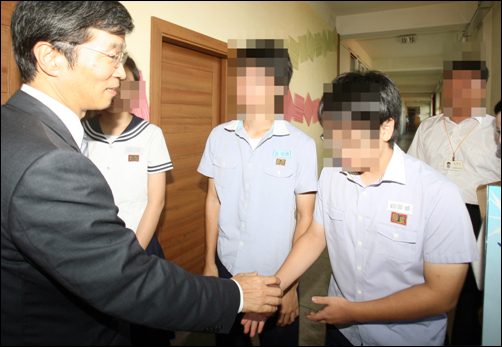 지난 9월 3일 서울의 한 중학교를 방문한 곽노현 서울교육감. 학생들이 가슴에 국가인권위에서 인권침해로 판단한 고정형 명찰을 달고있다.