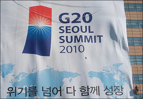 10월 26일 오후 서울 종로구 교보생명 본사 외벽에서 한 관계자가 오는 11월 11일 개막하는 G20 서울 정상회의를 알리기 위해 대형 현수막 설치 작업을 하고 있다.