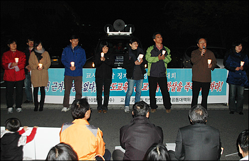 민주노동당에 후원금을 냈던 경남지역 교사들이 27일 저녁 경남도교육청 후문 앞에서 열린 집회에서 촛불을 들고 결의를 다지고 있다.