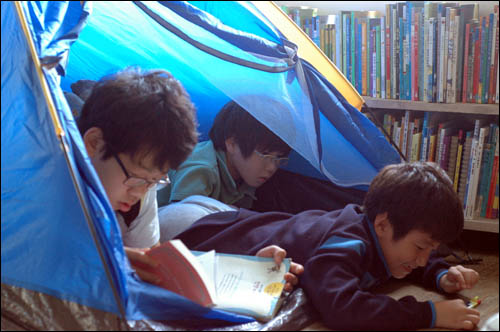 캠핑왔다가 작은 도서관에 텐트를 치고 책을 보는 '평화학교'아이들