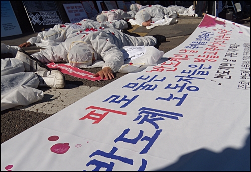 29일 반올림 활동가들이 '반도체의 날'을 규탄하는 기자회견에서 백혈병과 암에 쓰러져간 삼성 반도체 노동자들을 상징하는 퍼포먼스를 펼치고 있다.
