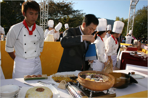  심사위원장(조용범, 한국조리학회장)이 출품된 음식평가를 위해 맛을 보고 있다.