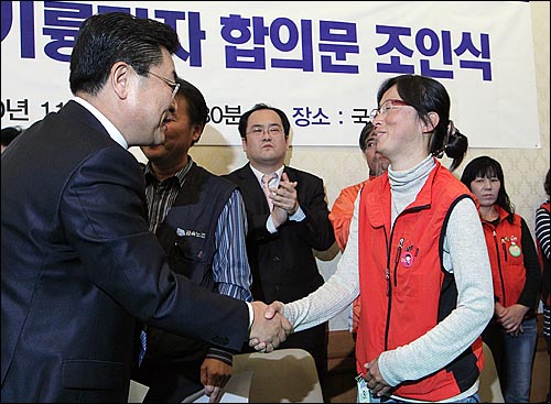 지난 2010년 11월 1일 국회 귀빈식당에서 열린 조인식에서 기륭전자 최동렬 회장과 김소연 기륭전자노조 분회장이 악수를 하고 있다.