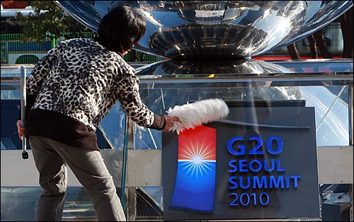 G20 정상회의 개막을 하루 앞둔 10일 오전 서울 강남구 삼성동 G20 정상회의 행사장인 코엑스 앞에서 한 근로자가 'G20 서울 서밋 2010'이 새겨진 조형물을 닦고 있다.