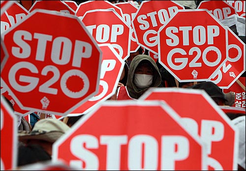 11일 오후 서울역광장에서 'G20대응민중행동' 주최로 열린 '사람이 우선이다! 경제위기 책임전가 G20규탄! 국제민중공동행의 날' 집회에서 참가자들이 G20을 반대하며 손피켓을 들어보이고 있다.