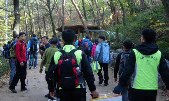 직장 조합원 80여명이 함께 한 아차산 산행에서 조합원들이 귤박스를 들고 가는 모습이다.