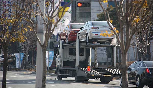 미쓰비시 자동차 광주전시장에 전시돼있던 자동차들이 트럭에 실려 16일 광주를 떠나고 있다.