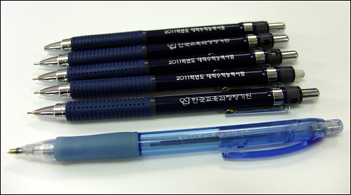 한국교육과정평가원이 2011년 대학수학능력시험 수험생들에게 제공한 샤프연필(사진위 5개). 아래 파란색 샤프연필은 2009학년도에 지급되었던 사프연필.