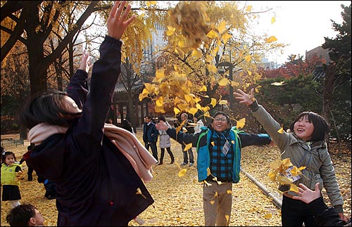 오마이뉴스가 주최하는 '제3회 나홀로 6학년들의 더불어 졸업여행'에 참석한 학생들이 24일 오후 서울 중구 덕수궁에서 낙엽을 던지며 즐거운 시간을 보내고 있다.
