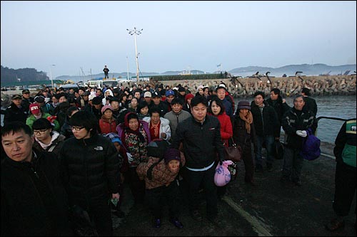북한군의 포격으로 하룻밤을 대피호에서 보낸 연평도 주민들이 24일 새벽 섬을 탈출하기 위해 짐보따리를 들고 부두로 몰려들고 있다.