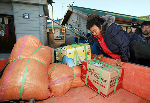 북한의 포격으로 초토화된 연평도에서 25일 주민들이 뭍으로 빠져나가기 위해 짐을 급히 챙겨 차에 오르고 있다.