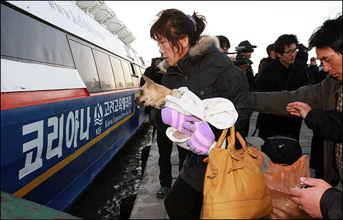 북한의 포격을 맞은 연평도 주민들이 대피하기 위해 25일 간단한 짐만 챙겨 뭍으로 향하는 배에 오르고 있다.