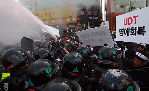 UDT 동지회 회원들이 27일 오후 서울 용산구 국방부 앞에서 북한의 연평도 포격에 대한 군의 미온적 초기 대응을 지적하는 국방부 규탄 기자회견을 갖고 도로 점거를 시도하다가 경찰들과 대치하며 소화기를 분사하고 있다.