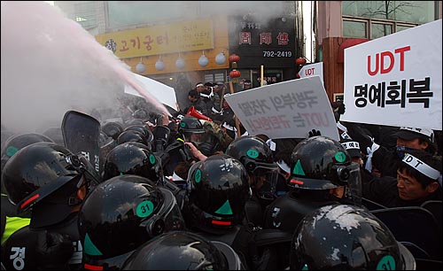  UDT 동지회 회원들이 27일 오후 서울 용산구 국방부 앞에서 북한의 연평도 포격에 대한 군의 미온적 초기 대응을 지적하는 국방부 규탄 기자회견을 갖고 도로 점거를 시도하다가 경찰들과 대치하며 소화기를 분사하고 있다.