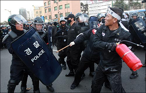  UDT 동지회 회원들이 27일 오후 서울 용산구 국방부 앞에서 북한의 연평도 포격에 대한 군의 미온적 초기 대응을 지적하는 국방부 규탄 기자회견을 갖고 도로 점거를 시도하며 경찰들과 충돌하고 있다.