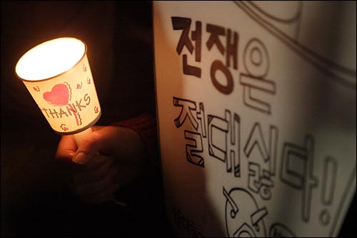 28일 밤 서울 종로2가 보신각앞에서열린 '전쟁반대 평화기원을 위한 시국기도회'에 대학생들이 '전쟁은 절대 싫다!'가 적힌 피켓을 들고 참석하고 있다.