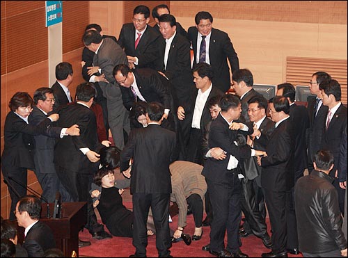 서울시의회에서 수적으로 우위에 있는 민주당 의원들이 의장석을 에워싸고 있던 한나라당 의원들을 끌어내고 있다.
