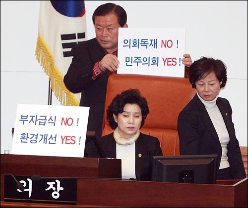 1일 오후 친환경무상급식 조례안 처리를 저지하기 위해 서울시의장석을 점거한 한나라당 의원들이 '부자급식 NO! 환경개선 YES!' '의회독재 NO! 민주의회 YES!'가 적힌 피켓을 세워놓고 있다.