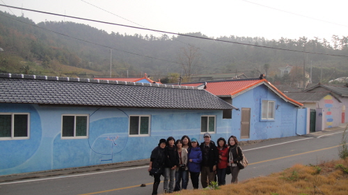  - 전남문화탐방단 10여 명이 김환기의 그림으로 채색된 안좌도의 민가 주택 앞에서 사진촬영을 했다.  

