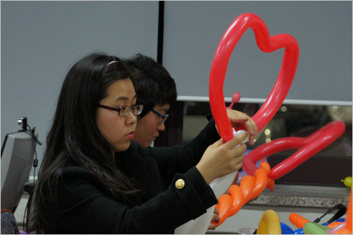 산타학교에서 배우는 풍선아트 교실의 모습. 하트 모양을 열심히 만들고 있다.