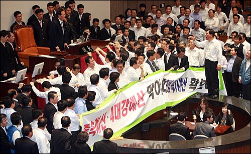 2010년 12월 8일 오후 서울 여의도 국회 본회의장에서 정의화 국회부의장이 2011년 예산안을 강행처리를 시도하자, 민주당과 야당 의원들이 단상을 에워싸고 4대강 예산 전액 삭감과 민생 복지 예산 확보를 요구하며 항의하고 있다.