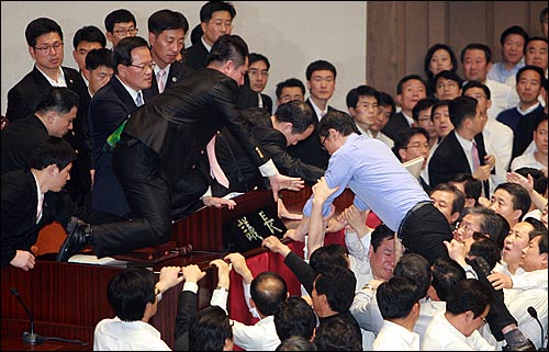 8일 오후 서울 여의도 국회 본회의장에서 정의화 국회부의장이 2011년 예산안을 강행처리를 시도하자, 홍영표 민주당 의원이 예산안 표결 처리를 막기 위해 의장석으로 뛰어오르고 있다.