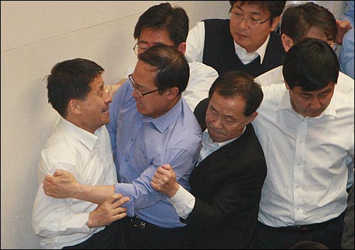 새해 예산안 처리를 놓고 여야가 대치를 벌이고 있는 가운데 8일 오후 서울 여의도 국회 본회의장 단상에서 차명진 한나라당 의원이 홍영표 민주당 의원과 야당 의원들을 끌어내리며 실랑이를 벌이고 있다.