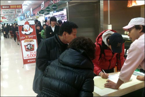 '5천 원 치킨' 판매가 시작된 지난 9일 오전 11시 롯데마트 영등포점에 예약 번호표를 받아든 고객 50여 명이 줄지어 기다리고 있다.