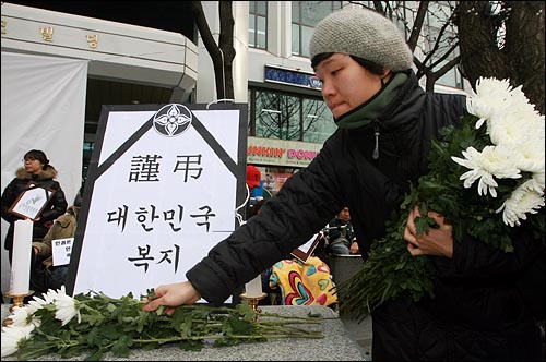  '세계인권선언 62주년'을 맞아 10일 오전 서울 중구 국가인권위원회앞에서 인권단체연석회의, 현병철인권위원장사퇴촉구대책회의 등이 주최한 기자회견에서 참석자들이 '근조 대한민국 복지'가 적힌 영정에 국회꽃을 놓고 있다.